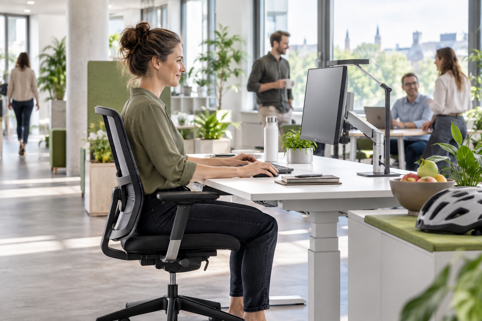 Mitarbeiterin an einem ergonomisch eingerichteten Arbeitsplatz mit dezenten Benefits